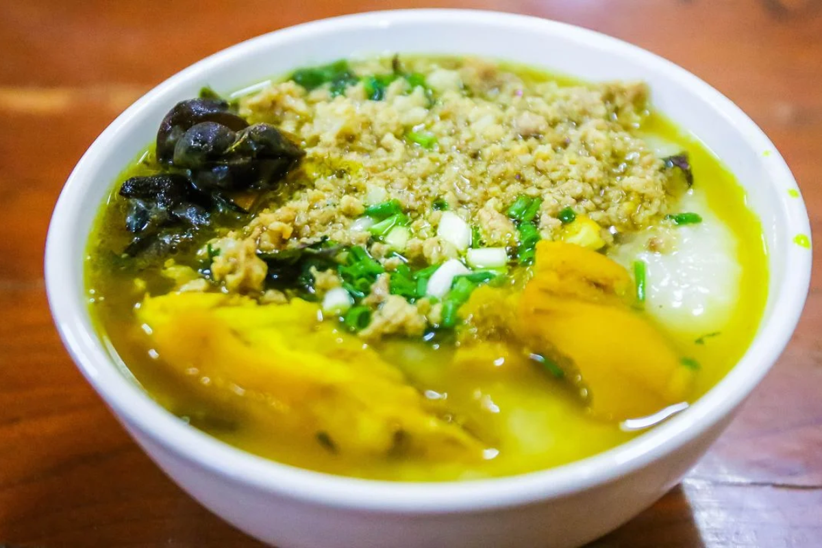 Bowl of Au Tau porridge with sticky rice, egg, and bamboo shoots